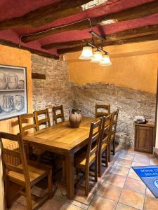 a dining room with a wooden table and chairs at Casa Rural La Tahona in Lerín