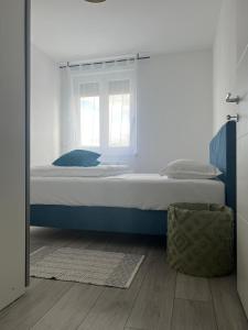 a bed in a white room with a window at Apartman Vrućica view in Teslić