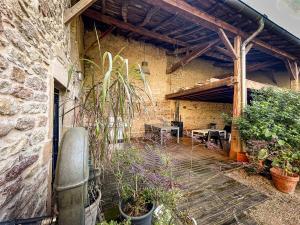 an outdoor patio with plants and a brick building at Le clos de Laly in Charnay-lès-Mâcon