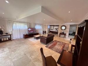 a large living room with a couch and a tv at Concordia Boutique Venue in Midrand