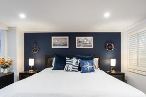 a bedroom with a large bed with blue walls at King Bed Harbour View - Captain's Retreat in Sydney