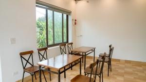 two tables and chairs in a room with a window at Tam Coc Gold Smile Homestay in Vũ Lâm