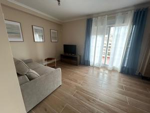 a living room with a couch and a television at El Ático de Brisaquebrada - Vista Mar - Gran Terraza in Benalmádena +25 photos