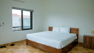 a bedroom with a bed and a window at Tam Coc Gold Smile Homestay in Vũ Lâm