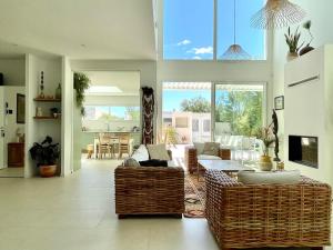 a living room with wicker furniture and a dining room at PGH N2 - Villa avec Piscine à 50m de la Plage in La Grande-Motte