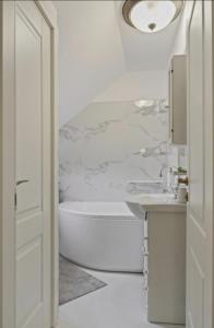 a white bathroom with a tub and a sink at White luxury house in Bucharest +16 photos