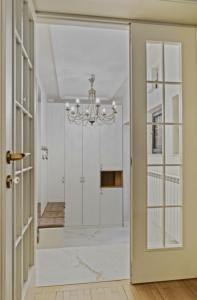a door leading into a hallway with a chandelier at White luxury house in Bucharest