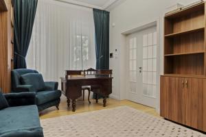 a living room with a piano and a blue chair at White luxury house in Bucharest