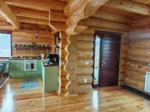a kitchen with wooden walls and a wooden floor at Cabana Om Bun in Piatra