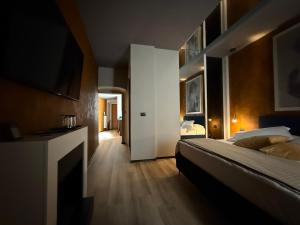 a bedroom with a bed and a television in it at KUDETÀ SUITE in Campobasso