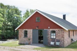 a red barn with two chairs in front of it at Unique house outside Borås in Fritsla
