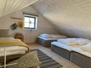 a attic room with two beds and a window at Unique house outside Borås in Fritsla