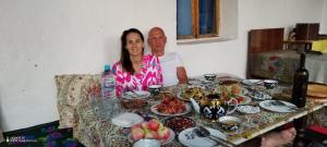 a man and a woman sitting at a table with food at Sentyab Obi chashma guest house in Tadzhimi