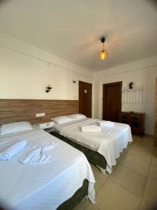 Dos camas en una habitación de hotel con sábanas blancas. en Ocean Life Otel, en Fethiye