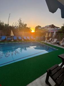 Una piscina con sillas y una puesta de sol al fondo. en Ocean Life Otel, en Fethiye