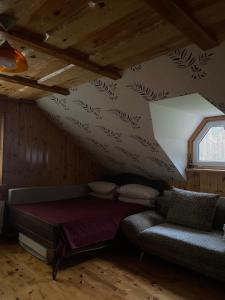 a room with a bed and a couch and a window at Dzūkų sodžius in Snaigupė