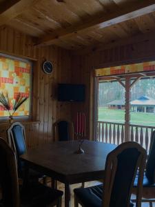 a dining room with a table and chairs and a window at Dzūkų sodžius in Snaigupė