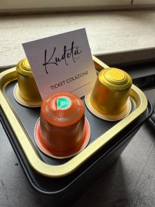 three different colored dishes on a tray with a sign at KUDETÀ SUITE in Campobasso