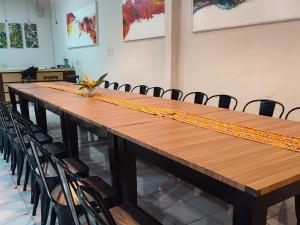 a long wooden table with chairs in a room at Esemka Hotel and Convention Kotabumi in Kotabumi +8 photos