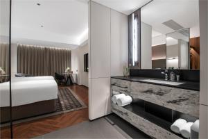 a bathroom with a bed and a sink and a mirror at Intercity Jinghong Xishuangbanna in Jinghong