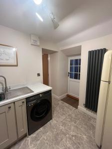 a kitchen with a washer and a sink and a dishwasher at Holiday home Irton in Seamer +5 photos