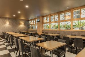 a dining room with tables and chairs and windows at Kindness Hotel - Chihkan Tower Branch in Tainan