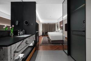 a bathroom with a sink and a bedroom at Intercity Jinghong Xishuangbanna in Jinghong