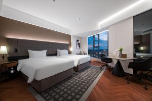 a hotel room with a large bed and a desk at Intercity Jinghong Xishuangbanna in Jinghong