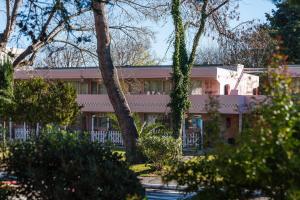 a pink building with trees in front of it at Kyriad Cannes - Mandelieu in Cannes