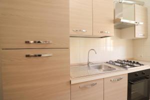 una cocina con fregadero y estufa en Casa Ambra a Otranto, en Otranto