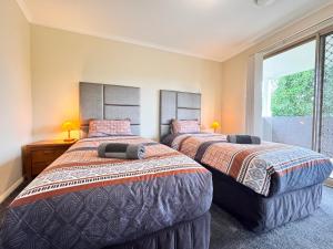 ペンリスにあるBlue Haven Retreat - Thornton Central 34の窓のある部屋にベッドが2つある
