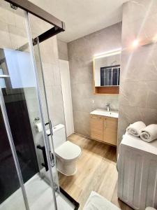 a bathroom with a shower and a toilet and a sink at Appartement spacieux à 450 m de la plage in Roses