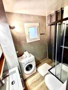 a small bathroom with a washing machine and a window at Appartement spacieux à 450 m de la plage in Roses +8 photos