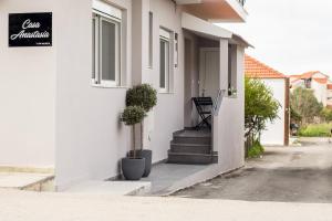 a white house with stairs and a sign on it at Casa Anastasia in Pastida