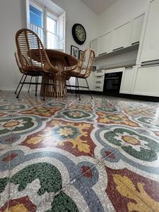 a kitchen with a table and chairs on a colorful rug at Stylish Boutique Duplex Apartment Home 'Green' - Near Valletta! 2 Large Double En-Suite Bedrooms in Msida +84 photos
