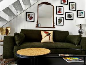 a living room with a green couch and a table at Stylish Boutique Duplex Apartment Home 'Green' - Near Valletta! 2 Large Double En-Suite Bedrooms in Msida