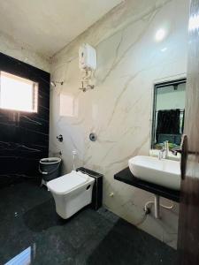 ein Badezimmer mit einer weißen Toilette und einem Waschbecken in der Unterkunft Footprints Villa in Panchgani