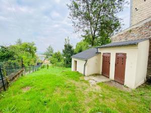 a building with two doors on the side of a yard at Rez-de-chaussée Saint Marcel jardin partagé in Laon