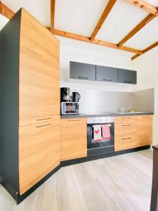 a kitchen with wooden cabinets and a stove at Rez-de-chaussée Saint Marcel jardin partagé in Laon