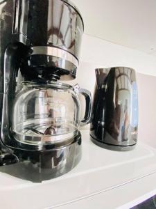 a coffee maker on a shelf next to a cup at Rez-de-chaussée Saint Marcel jardin partagé in Laon