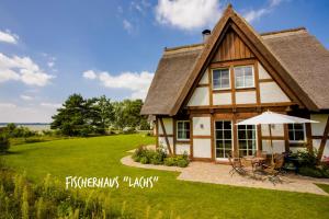 a house with a patio and a lawn at Fischerhäuser in Quilitz in Quilitz