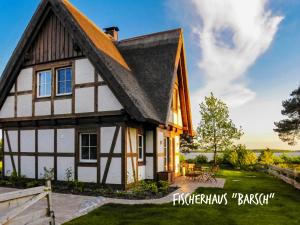 a house with a black and white roof at Fischerhäuser in Quilitz in Quilitz