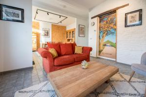 GenappeLe Bivouac的客厅里有一张红色的沙发和一张咖啡桌
