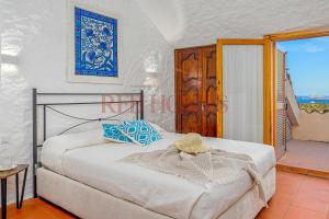 a bedroom with a bed with a hat on it at Domus de pedra in Marina di Portisco