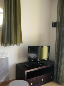 a flat screen tv sitting on top of a black cabinet at Terrasses des Embiez in Six-Fours-les-Plages