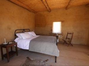 Un dormitorio con una cama, una mesa y una silla. en Bloukrans Klein-bewarea Guest Farm, en Laingsburg