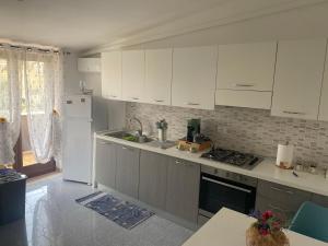 una cucina con mobili bianchi e un lavello di Gine's Tropea Home a Tropea