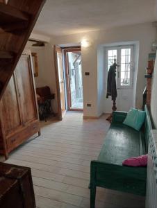 a living room with a green couch and a window at La Persellina House in Sant' Agata fossili