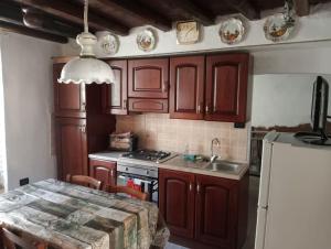 a kitchen with wooden cabinets and a table with a sink at La Persellina House in Sant' Agata fossili