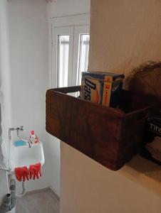 a wooden basket on a wall next to a sink at La Persellina House in Sant' Agata fossili +19 photos